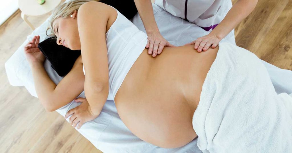 Full term pregnant woman receiving an induction massage.